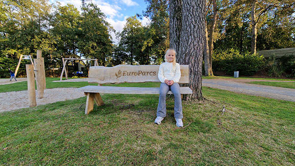 Meisje aan het rusten op een bankje in de speeltuin op EuroParcs De Zanding