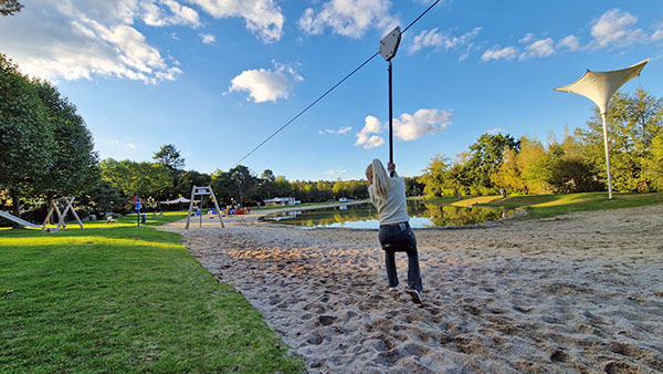 Meisje aan het spelen in de speeltuin aan het recreatiemeer op EuroParcs De Zanding.