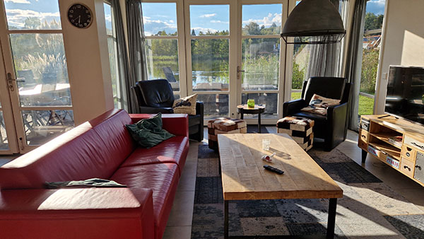 Woonkamer met grote glazen pui in de Strandvilla op vakantiepark De Zanding