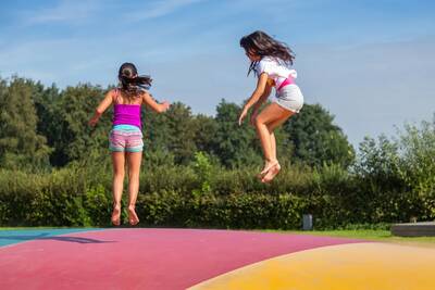 Children jump on the air trampoline in the playground at the EuroParcs Zuiderzee holiday park