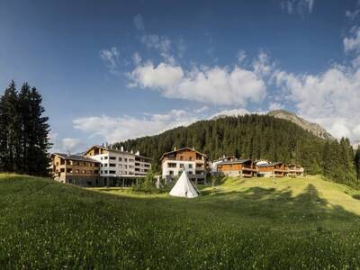 Blick von einem Berg in der Schweiz auf die Landal Alpine Lodge Lenzerheide