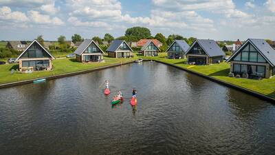 Luchtfoto van mensen in kano's en vakantiehuizen op Landal Waterpark De Alde Feanen