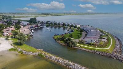 Luchtfoto van vakantiehuizen op Makkumbeach Beach Resort Makkum en het IJsselmeer