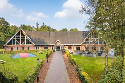 Het hoofdgebouw en speeltuin van vakantiepark Roompot Landgoed Het Grote Zand