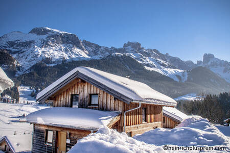 Vrijstaand houten chalet in de sneeuw op Alps Resorts Alpendorf Dachstein West