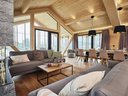 Ruime woonkamer met open haard van een chalet op Alps Resorts Bergresort Hauser Kaibling