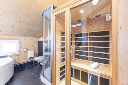 Badkamer met bad, toilet en sauna in een vakantiehuis op Alps Resorts Feriendorf Murau