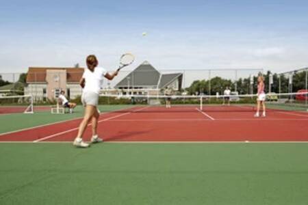 Mensen aan het tennissen op de tennisbaan op vakantiepark Beach Resort Makkum