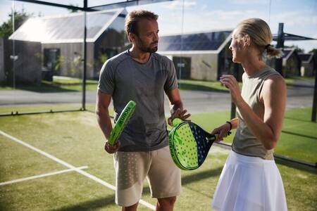 Stel speelt een potje padel, een combinatie tussen squash en tennis op vakantiepark Brinckerduyn