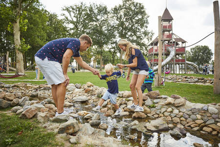 Spelende kinderen bij het speel riviertje in de speeltuin op Buitenhof de Leistert.