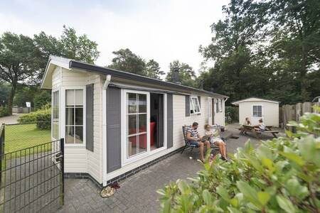 Mensen in de tuin van een chalet op vakantiepark Camping de Noetselerberg