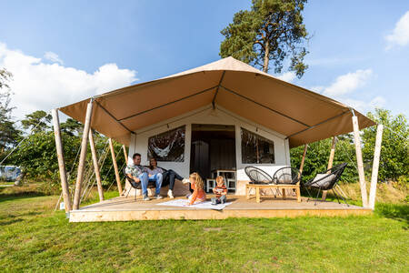 Mensen onder de luifel van een safaritent op vakantiepark Camping de Norgerberg