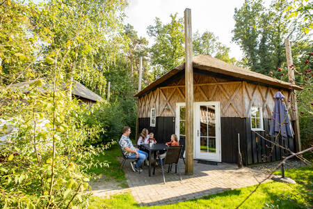 Mensen in de tuin van een vakantiehuis op vakantiepark Camping de Norgerberg