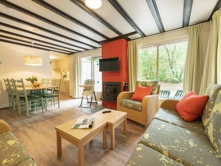 Woonkamer met haard en eethoek van een vakantiewoning op Center Parcs Limburgse Peel