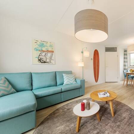 Woonkamer met bank en eethoek in een vakantiewoning op Center Parcs Park Zandvoort