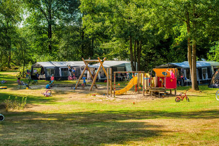 Kampeerveld met een speeltuintje op camping De Berenkuil in Grolloo