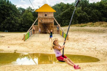 Kinderen op een kabelbaan in een speeltuin op camping De Berenkuil in Grolloo