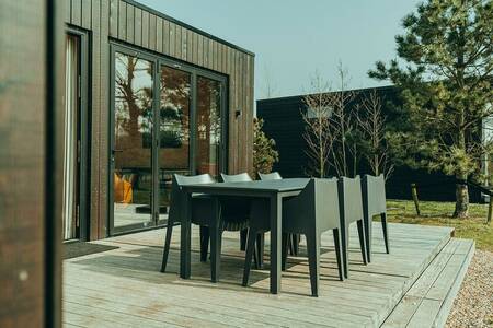 Terras met tuinstoelen van een vakantiehuis op vakantiepark De Klepperstee