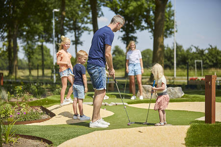 Gezin aan het minigolfen op de adventure golfbaan van de Leistert