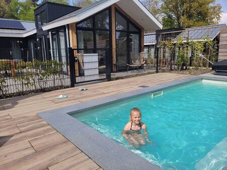 Meisje aan het zwemmen in een privé zwembad bij een Pool Lodge op vakantiepark De Thijmse Berg