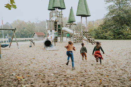 Kinderen rennen naar een groot klimtoestel in een speeltuin op vakantiepark Dierenbos