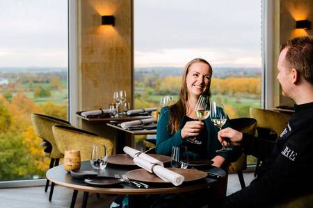 Man en vrouw in het panoramarestaurant "Rantrée" op vakantiepark Dormio Resort Maastricht