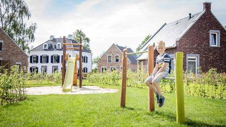 Kind in een speeltuin in het Kidskwartier bij Kidswoningen op vakantiepark Dormio Resort Maastricht