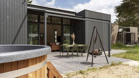 Vuurkorf en hottub in de tuin van een vakantiehuis op vakantiepark Dutchen Park de Zeegser Duinen