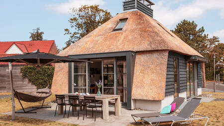 Tuin met hangmat, eettafel en ligstoelen bij een vakantiehuis op vakantiepark Dutchen Park Weideduyn