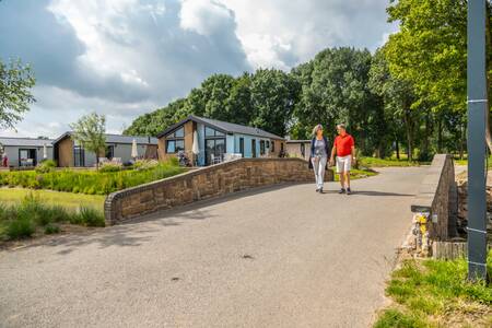 Stel wandelt over een brug op vakantiepark EuroParcs Aan de Maas