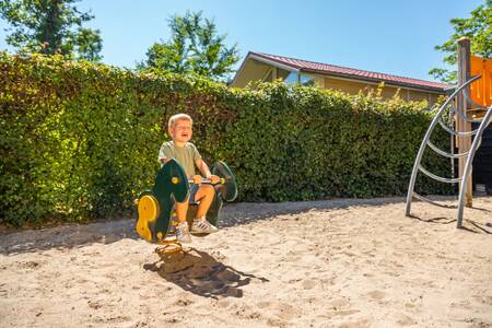 Kindje speelt in de speeltuin op vakantiepark Europarcs Bad Hoophuizen