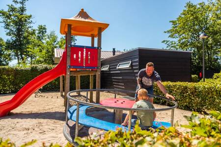 Vader en kind spelen in de speeltuin op vakantiepark Europarcs Bad Hoophuizen