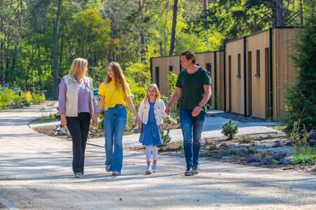 Gezin wandelt langs vakantiehuizen op vakantiepark EuroParcs Beekbergen