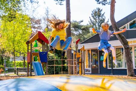 Kinderen springen op de airtrampoline in een speeltuin op vakantiepark EuroParcs Beekbergen
