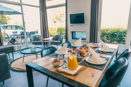 Gedekte tafel in een woonkamer van een vakantiehuis op vakantiepark EuroParcs De Biesbosch