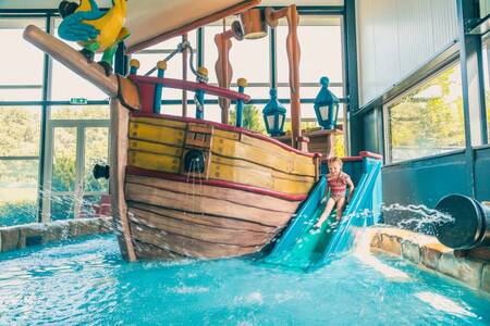 Kindje op de glijbaan in het peuterbad van vakantiepark EuroParcs De Biesbosch