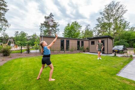 Kinderen aan het badmintonnen in de tuin van een vakantiehuis op EuroParcs De Hooge Veluwe