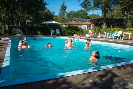 Mensen zwemmen in het buitenbad van vakantiepark EuroParcs de Wiltzangh