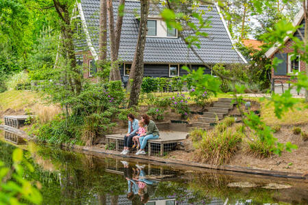 Gezin op een steiger bij een vakantiehuis op vakantiepark EuroParcs de Zanding