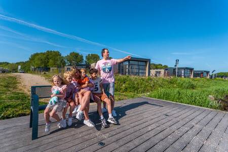 Gezin zit op een steiger aan het IJsselmeer op vakantiepark EuroParcs Enkhuizer Strand