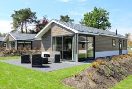 Tuin met loungestoelen van een chalet op vakantiepark EuroParcs Limburg