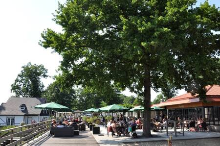 Mensen op het terras van het restaurant op vakantiepark EuroParcs Limburg