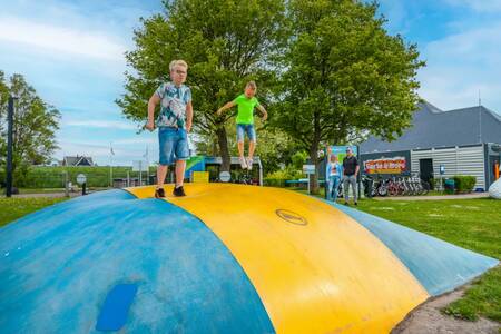 Kinderen springen op de airtrampoline op vakantiepark EuroParcs Markermeer