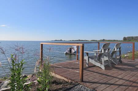 Stoelen op een steiger met uitzicht over het Markermeer op vakantiepark EuroParcs Markermeer