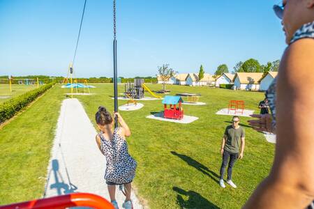 Kinderen op een kabelbaan in een speeltuin op vakantiepark EuroParcs Poort van Maastricht