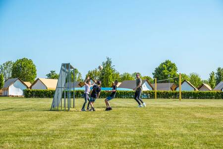 Gezin aan het voetballen op het voetbalveld op vakantiepark EuroParcs Poort van Maastricht