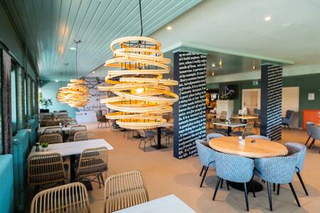 Tafels met stoelen in het sfeervolle restaurant op vakantiepark EuroParcs Schoneveld