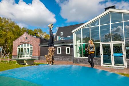 Kinderen springen op de airtrampoline in de speeltuin op vakantiepark EuroParcs Spaarnwoude