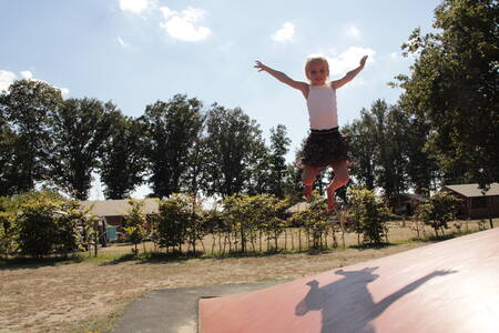 Meisje aan het spelen op een airtrampoline op vakantiepark Krieghuusbelten