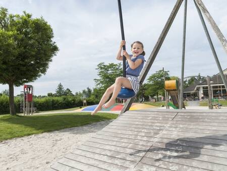Kind op de kabelbaan in de speeltuin op vakantiepark Landal Aelderholt